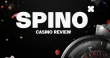 Spino casino review banner with roulette wheel, playing cards and colorful casino chips on a dark black casino background.